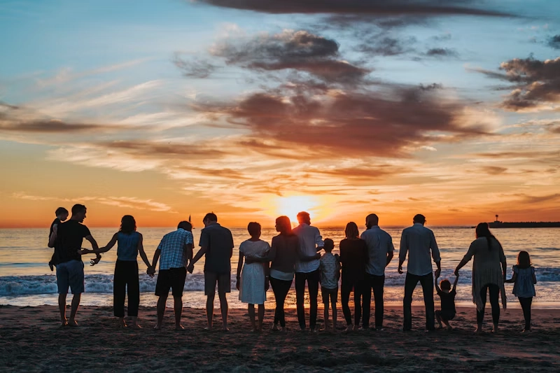 Genitori e bambini che camminano mano nella mano all'aperto nella luce calda del tramonto
