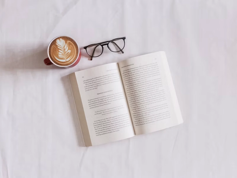 Libro fotografico aperto su un tavolo in legno con una tazza di caffè